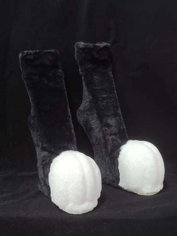 Furry black and white recurved legs and animal feet